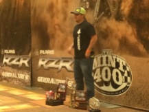A winner poses with his prizes after the 2015 Polaris RZR Mint 400 awards banquet.